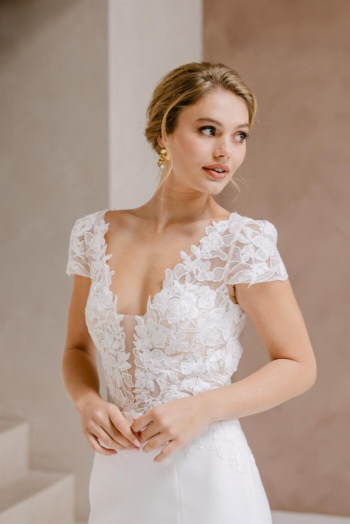 Das Brautkleid Soraya von Marylise Elegantes Brautkleid „Soraya“ von Marylise mit floralem Spitzenoberteil, tiefem V-Ausschnitt, kurzem Ärmel und Beinschlitz