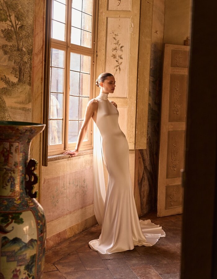 Das Brautkleid Whitney von Alberto Palatchi Brautkleid Whitney von Alberto Palatchi aus Satin in einem fließenden Fit-and-Flare-Schnitt mit Neckholder und mit kurzer Schleppe