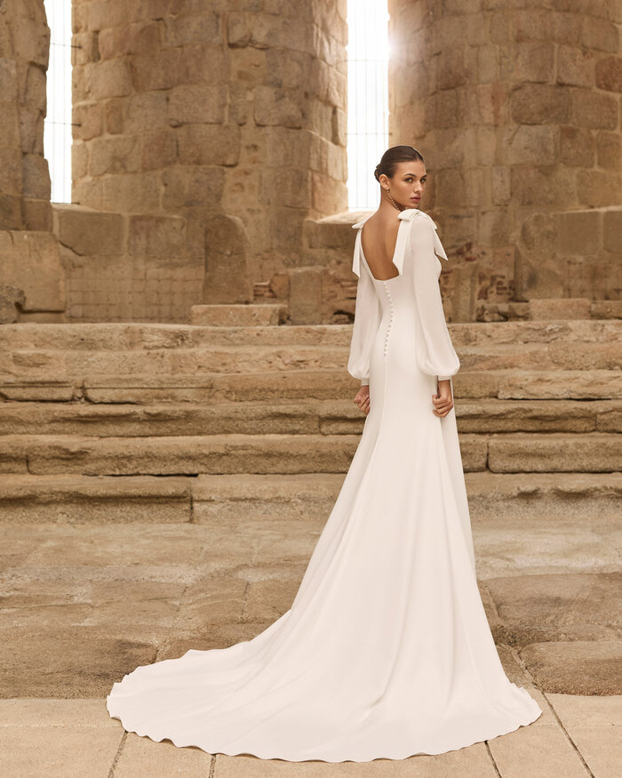 Das Brautkleid Paiva von Rosa Clara Brautkleid Paiva von Rosa Clará aus schlichtem Crêpe Stoff in schmaler Silhouette mit abnehmbaren Chiffonärmeln