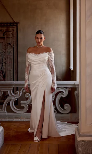 Curvy Brautkleid Jessa von Justin Alexander mit schulterfreiem Ausschnitt, langen Spitzenärmeln, figurbetonter Fit-and-Flare-Silhouette und Beinschlitz – elegantes Plus-Size Hochzeitskleid in Ivory für moderne Bräute.