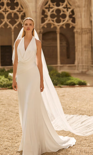 Das Brautkleid Lavanda von Rosa Clara Brautkleid Lavanda von Rosa Clará mit elegantem Neckholder-Ausschnitt, drapiertem Oberteil und fließender Silhouette mit langer Schleppe