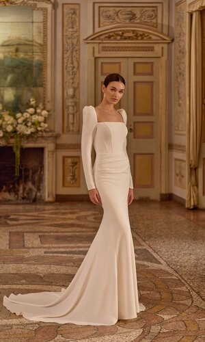 Das Brautkleid Bellis von Alberto Palatchi Brautkleid Bellis von Alberto Palatchi mit elegantem eckigem Ausschnitt, langen Ärmeln, figurbetontem Schnitt und ausgestelltem Rock mit Schleppe