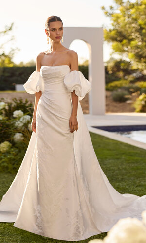 Das Brautkleid Nur von Rosa Clara Brautkleid Nur von Rosa Clará in Ivory mit elegantem schulterfreiem Ausschnitt, figurbetonter Silhouette, fließendem Rock und moderner Schleppe – hochwertiges Hochzeitskleid für stilvolle Bräute.