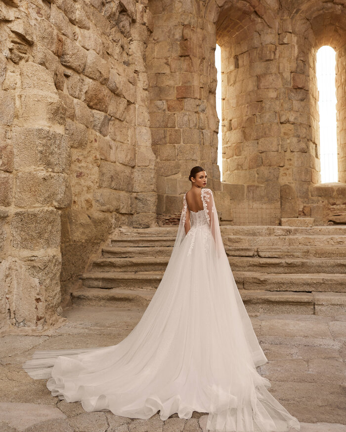 Das Brautkleid Petalo von Adriana Alier Romantisches weißes Brautkleid mit floraler Spitze,glitzernden Pailletten im fließenden Rock und langer Schleppe in der Rückenansicht