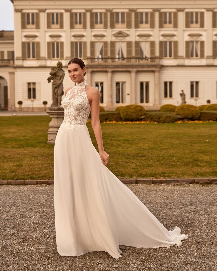 Das Brautkleid Favia von Alberto Palatchi Brautkleid Favia von Alberto Palatchi mit hochgeschlossenem floralem Spitzenoberteil mit Neckholder, taillierter Silhouette und fließendem A-Linien-Rock mit Spitzen-Schleppe