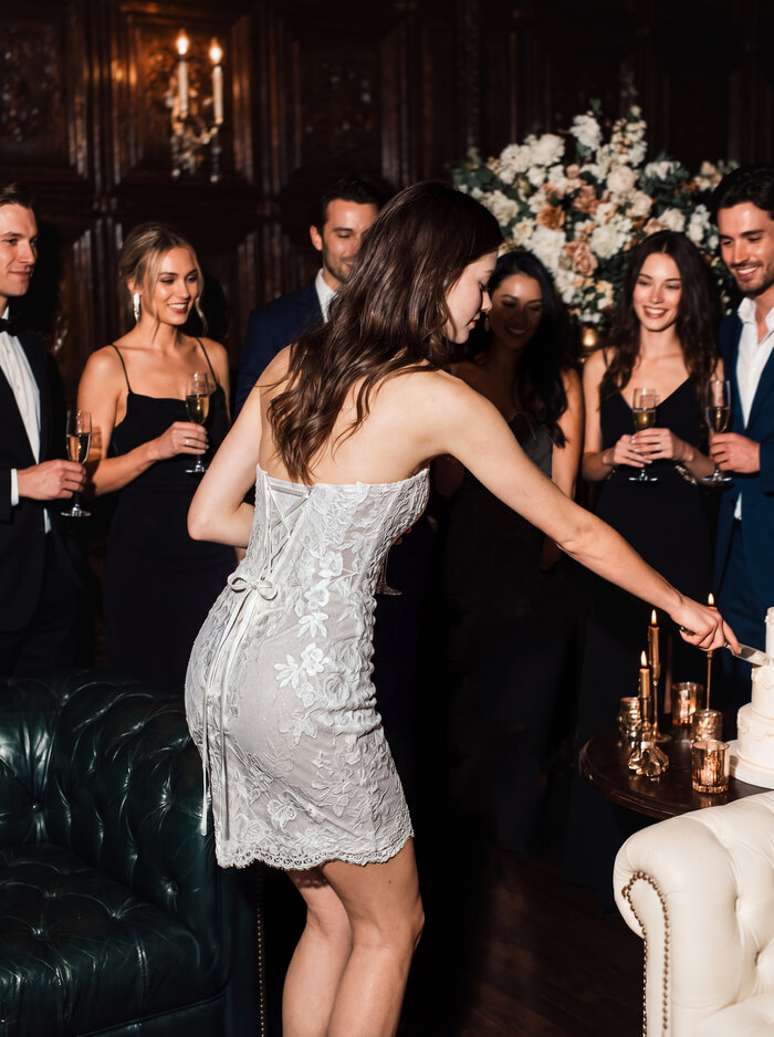 Brautkleid Olea von Modeca Kurzes Spitzen-Brautkleid mit herzförmigem Ausschnitt für Standesamt und stilvolle Hochzeitsparty in Rückenansicht.