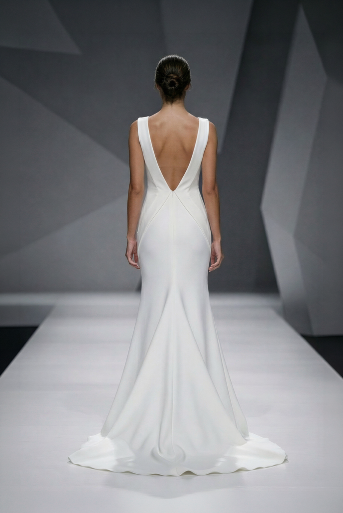 Das Brautkleid Amelia von Lili Pellegrino Modernes schlichtes Brautkleid mit V-Ausschnitt, figurbetontem Schnitt, tiefem Rückenausschnitt und eleganter Schleppe in der Rückenansicht