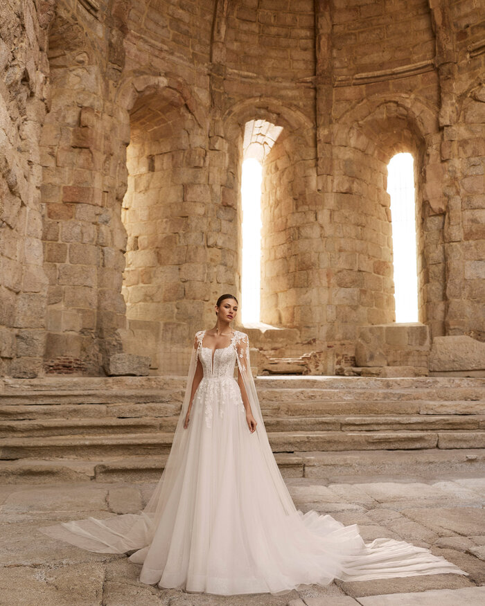 Das Brautkleid Petalo von Adriana Alier Romantisches weißes Brautkleid mit floraler Spitze,glitzernden Pailletten im fließenden Rock und langer Schleppe