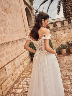 Das Brautkleid Merysol von Modeca Das Brautkleid Merysol von Modeca mit Tüllrock mit einem Perlen verzierten Spitzenoberteil und Federn