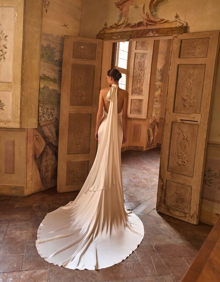 Das Brautkleid Whitney von Alberto Palatchi Brautkleid Whitney von Alberto Palatchi aus Satin in einem fließenden Fit-and-Flare-Schnitt mit Neckholder und mit kurzer Schleppe