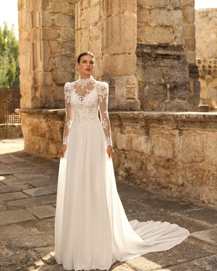Das Brautkleid Papiro von Adriana Alier Brautkleid Papiro von Adriana Alier mit floraler Spitze, tiefem V-Ausschnitt, feinen Trägern und fließendem Rock mit Schleppe und Spitzenjäckchen