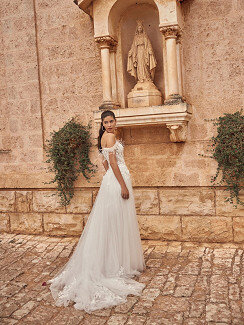 Das Brautkleid Merysol von Modeca Das Brautkleid Merysol von Modeca mit Tüllrock mit einem Perlen verzierten Spitzenoberteil und Federn